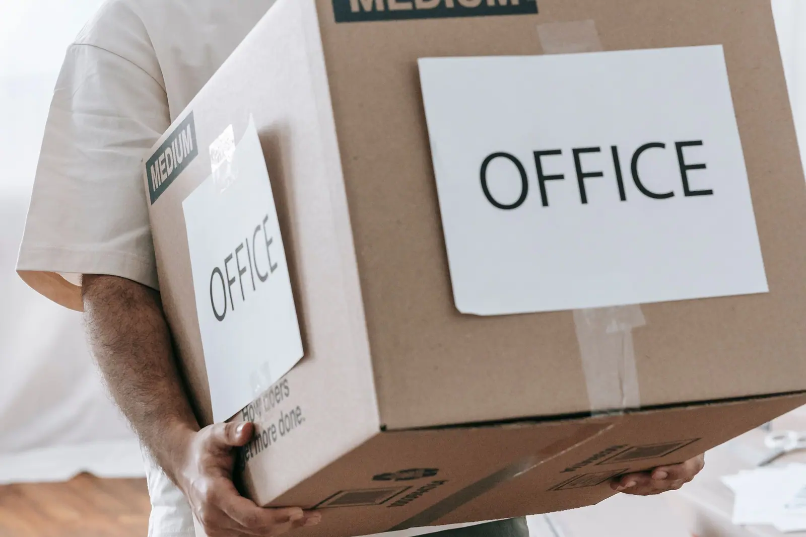Üzerinde OFİS yazan koliyi taşıyan eller